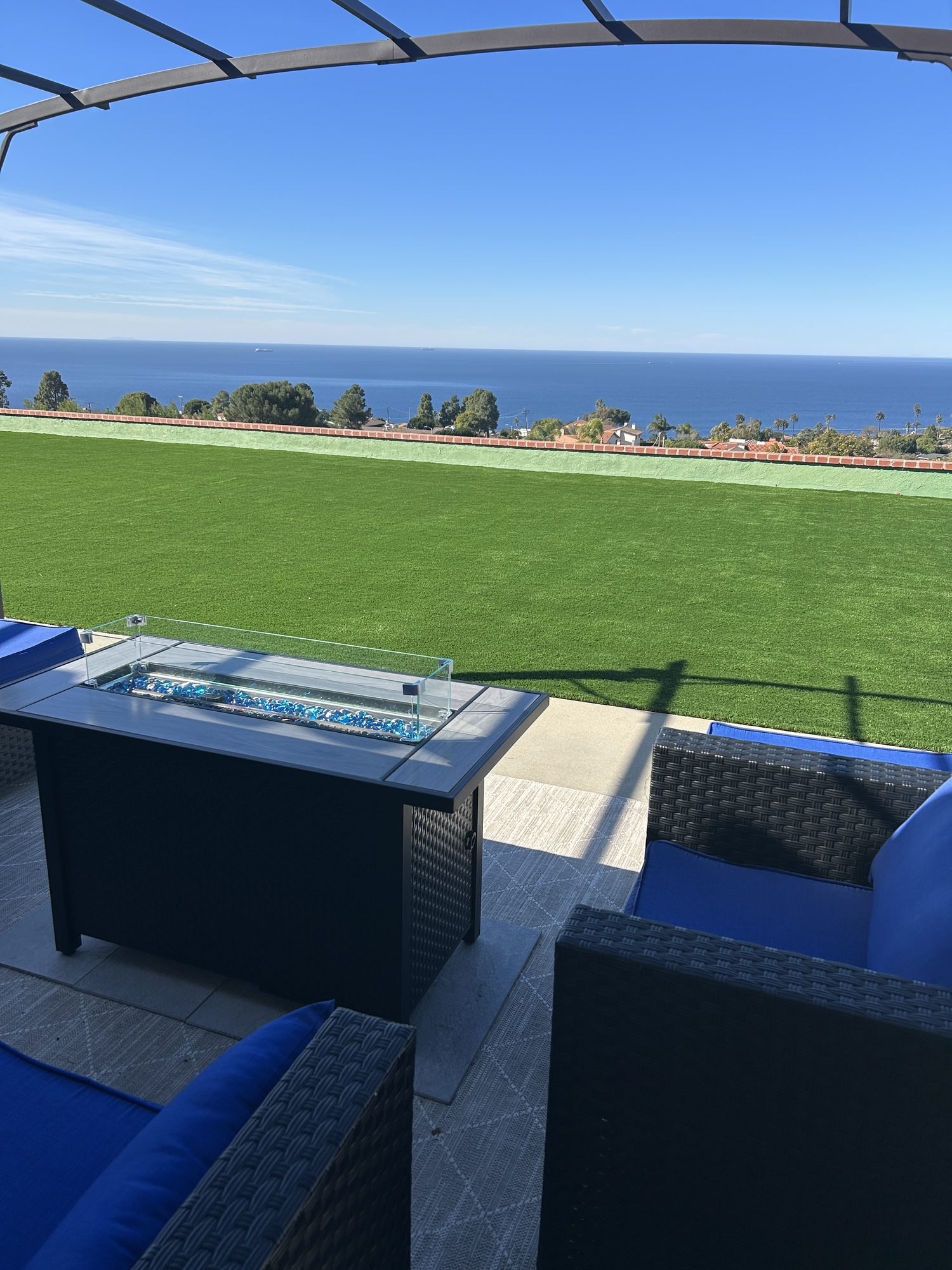 Ocean-view patio with a fire-pit lounge overlooking the coastline